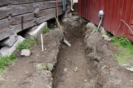 Schakt i område 2, mellan kyrkstugorna i innergårdens N hörn. Vid grävning av schaktet började vatten strömma in pga av den dåliga dräneringen runt stugorna. Bilden är tagen från S.