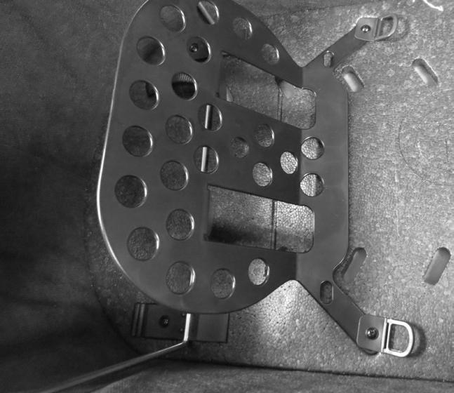 Presione hacia abajo el botón de la parte de plástico (4). Pase la barra de metal por encima del botón (5).