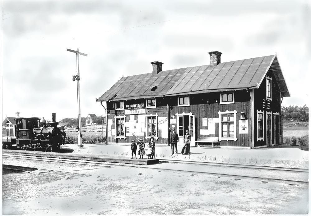 Den förenade post- och järnvägsstationen i Täby Kyrkby utmed Roslagsbanan Stockholm-Rimbo. Obs. reklamskylten Van Heutens Cacao på stationsbyggnaden. Möjligen tidigt exempel på intäkter från reklam.