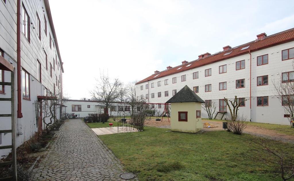 Bostadshusen har tre våningar varav nedervåningen är slätputsad och avfärgad i grått och övre delen av fasaden är klädd med eternitskivor i en ljust gul kulör.
