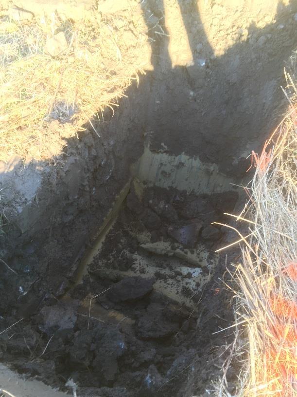 14(17) Figur 11. Foto visar Pg 1810, fyllnadsmassor av mulljord ovan lera, tegel och krukskärva ligger i botten på gropen, 2018-01-09. 5.