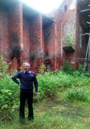 Pastor Juri Wolodarskij firar gudstjänst trots att större delen av kyrkan ligger i ruiner. bi skulle mässan firas.