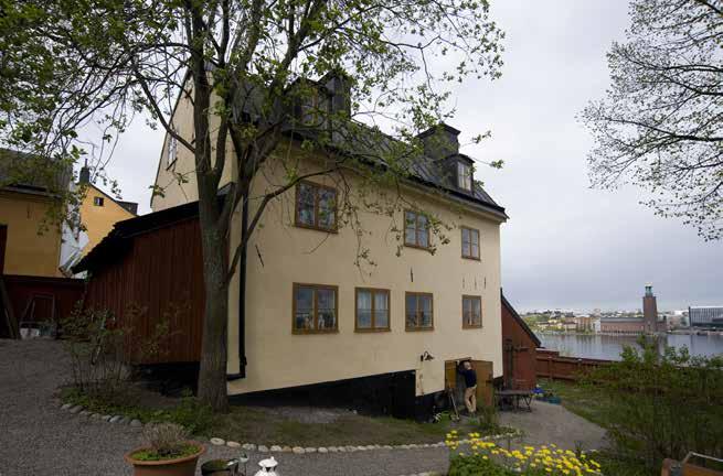 BOSTADSHUSETS ÖSTRA FASAD MED INGÅNG TILL KÄLLAREN OCH TRÄDGÅRD. FOTO J. MALMBERG på tegelstenstrappa till bottenvåningens trapphus. Bottenvåningen kunde nås från gatan och hade ett stenlagt trapphus.