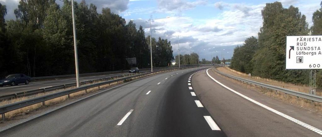 Sandbäcksgatan löper parallellt med E18 på dess östra sida och passerar under motorvägen vid Klarälvens strand.