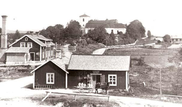 Huset till vänster med den höga skorstenen är Kils Mejeri AB. Affären rakt fram är Sjögrens diversehandel. På vagnen som dras av hästen står fyrkantiga mjölkkrukor.