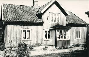 Villa i rött tegel med två förskjutna huskroppar. Välbevarad 1960-talskaraktär. Ligger fint på en kulle omgiven av tidstypiska tallar och tujaplanteringar. Häljered 2:4. Olof Persgården.