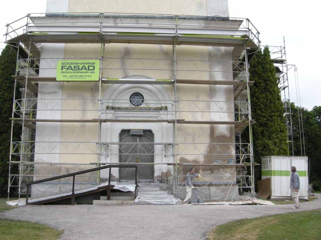 Ill. 6. Söderhamns fasad under pågående fasadrenovering av tornets nedre partier. Foto från söder, Daniel Olsson, Länsmuseet Gävleborg, 2009-07-07. kulturkalkfärg i obruten vit kulör nyttjats.