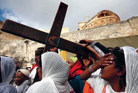 Etiopiska ortodoxa kristna bär ett kors vid Heliga gravens kyrka i Jerusalem under påsk - hög