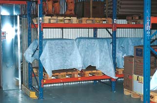 Förvaring av möbler i ett pallställ. Pallstället är uppställt så att det går att städa under det. Möblerna är täckta för att skyddas mot luftburna partiklar.