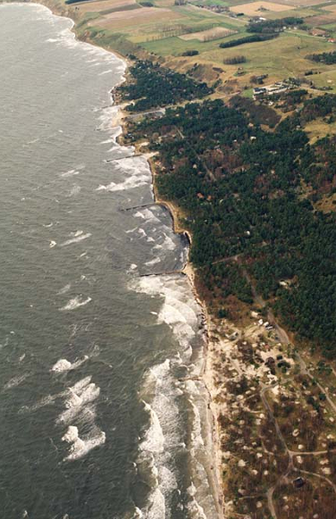 en bit ut i vattnet för att låta sand ackumuleras i det lugna vattnet innanför tröskeln.