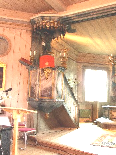 Inredning och inventarier Koret är förhöjt med ett trappsteg och altaret är uppställt på ett gråmålat träpodium som avgränsas av altarringen.