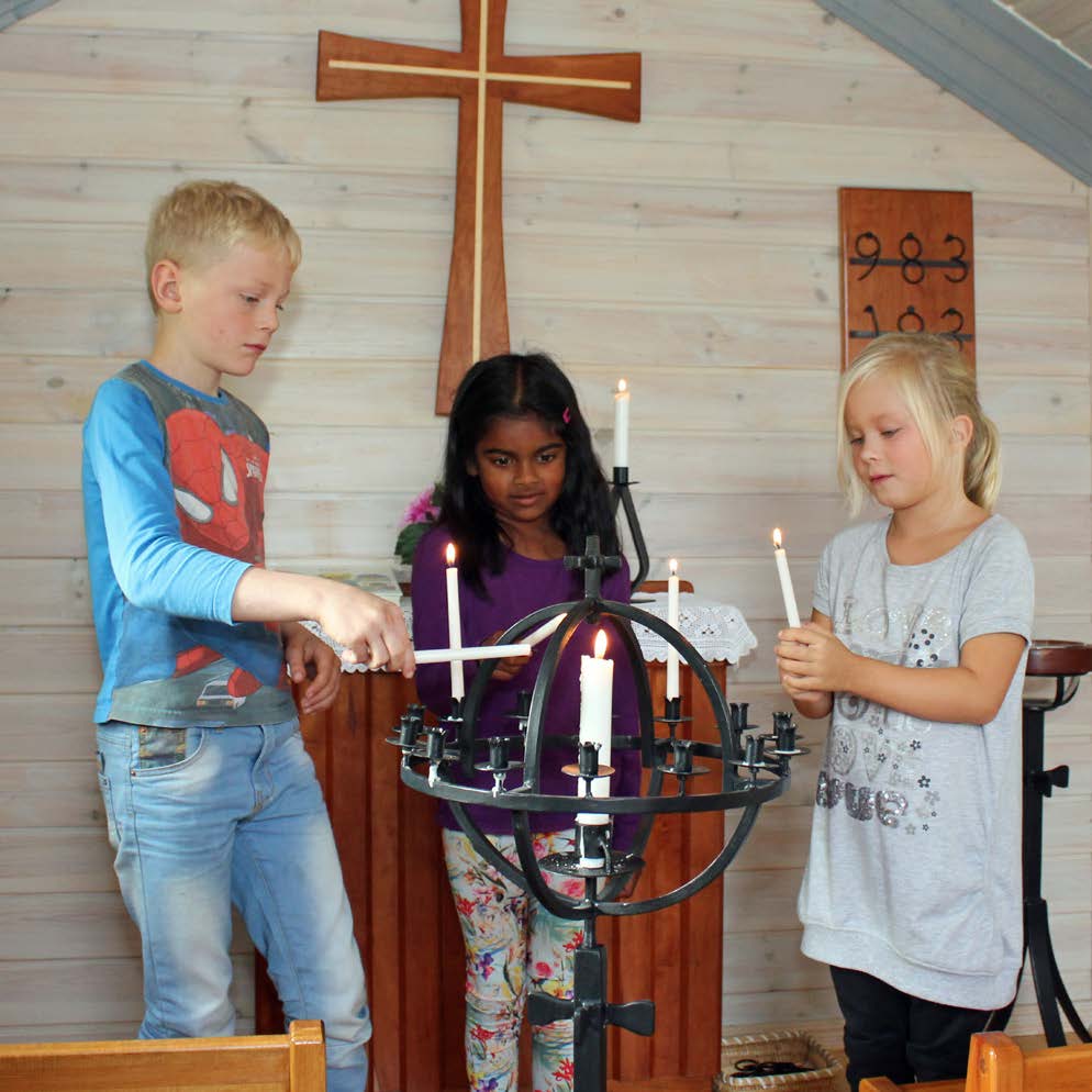 KYRKDÖRREN Melvin Lanquist, Maya Dahlström och Emma Lindberg tänder ljus i