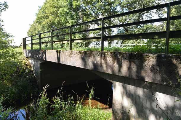 12-241-1 Bro över Bråån vid Sebbarp östra bron) Brons form domineras av den låga fria höjden och spännvidden i förhållande till kantbalkens höjd.