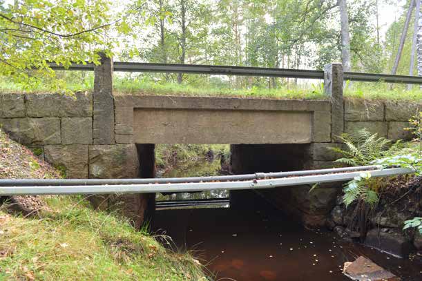 11-898-1 Bro över bäck o Emmaljunga Mycket välhållen plattbro av betong i ett spann med ursprungliga stengardister integrerade med sidomurarna vid landfästet.