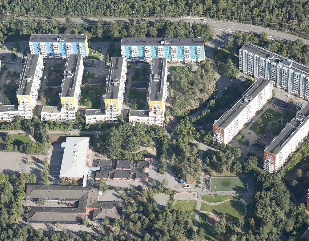 I Grantorp ligger storskaliga färgstarka byggnader insprängda i den skogsbeklädda terrängen.