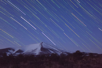 Fotografera stjärnspår (Stjärnspår) 4 Fotografera. z Tryck ned avtryckaren helt. [Upptagen] Strimmor som skapas av stjärnornas rörelser på himlen registreras på en enda bild.