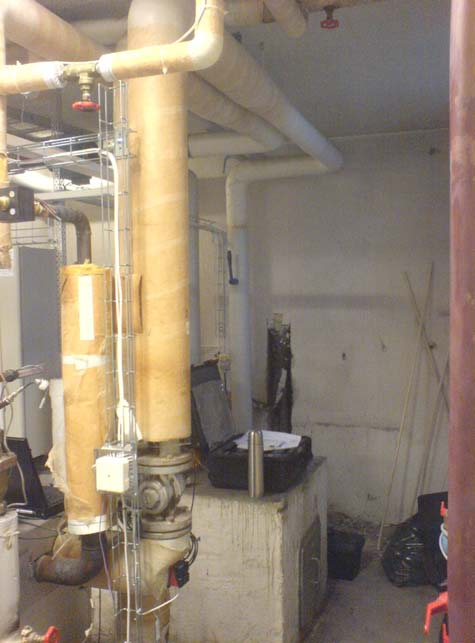 Figur 11 Till vänster: Cedergatans cirkulationspump sitter placerad i ett U-rör. Till höger: Pumpen syns i bakgrunden, nere till vänster i förgrunden syns radiatorväxlaren.