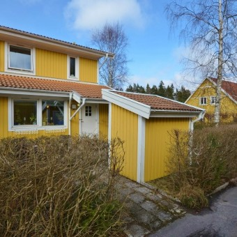 Exteriör Gavelradhus med stor tomt - gräsytor samt ett äppelträd. Kallförråd på entrésidan. Stenlagd uteplats med förmiddagssol på entrésidan.