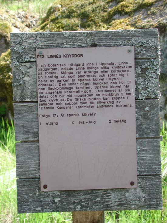 De skyltar som informerar om Linnés Hammarby är fästade på brädor som är vackert lavbevuxna. trots att lokalen anges som Linnés Hammarby.
