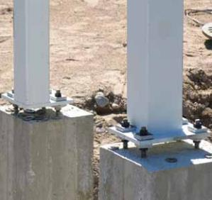 gjuts in i betongplattan när fundamentet gjuts. I pelarfötterna finns en fastsvetsad fotplåt. Fotplåten fästs på undre skruvar som sitter ovanför fundamentet.