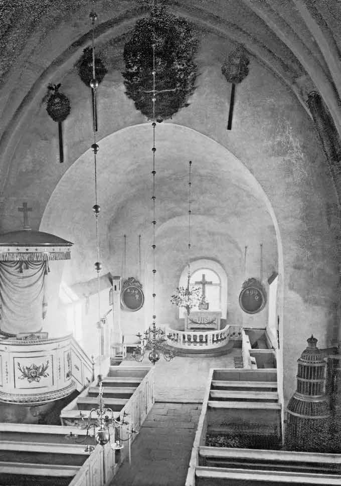 Fig. 70. Den vitstrukna Upplandskyrkan: Funbo före 186 års restaurering. På altaret står ett förgyllt kors från 1820. Predikstolen är från samma decennium, den vitmålade bänkinredning från 1676.