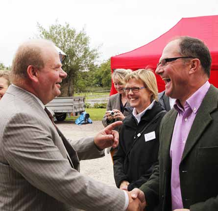 Foto: Hans Jonsson Greppa Näringens 10-års jubileum på Annelövs gård, Eskil Erlandsson hälsar på värden Bengt Hellerström medan projektledare Stina Olofsson myser i bakgrunden.