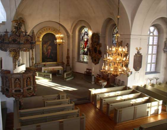 2 Det stora och ljusa kyrkorummet har vitmålade väggar och tak, liksom korsarmarnas tunnvalv och högaltarets hjälmvalv.