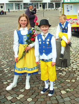 De har kommit direkt från skolan för att välkomna och sprida blomsterlycka hos gästande kryssningsturister som snart ska återvända till sitt flytande hotell.