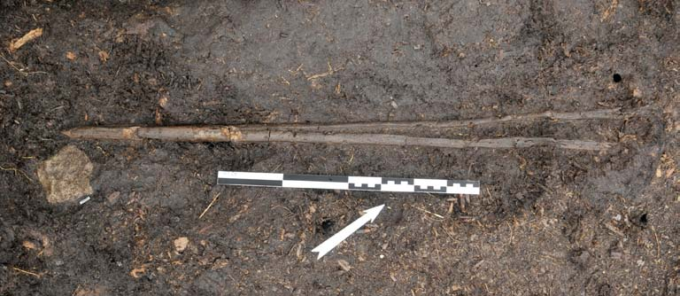 21 och 26). Diametern är 26 mm och längden 890 mm och har bark kvar i den ohuggna, okluvna delen. En liknande kluven hasselkäpp påträffades 1998 i samband med undersökningen av boplats R6.