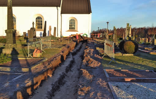 Matjordslagret under den asfalterade ytan minskade till 0,4 0,5 meter utanför kyrkogården. Undergrunden bestod av moräninblandad brun sand. Figur 5.