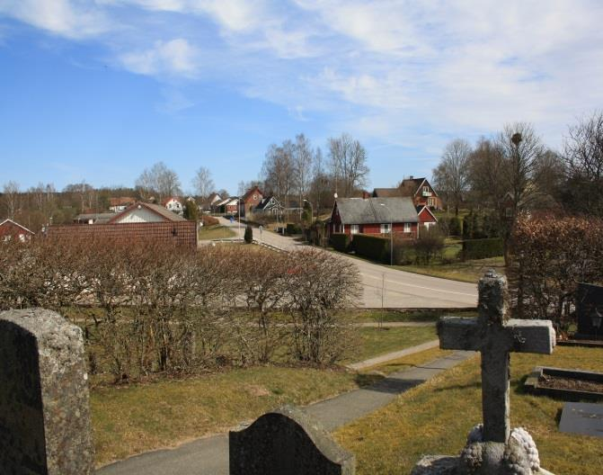 Utsikt mot bebyggelsen nordöst om kyrkogården. Avgränsande häck mellan askgravlunden och minneslunden. Omgivningar Röke kyrka ligger högt belägen i landskapet.