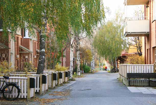 21 Bostadsområde i kv Laxen, 1980-tal Gångstråk genom bostadsområdet. Till vänster radhus, till höger flerbostadshus. Ett gemensamt formspråk håller samman miljön.