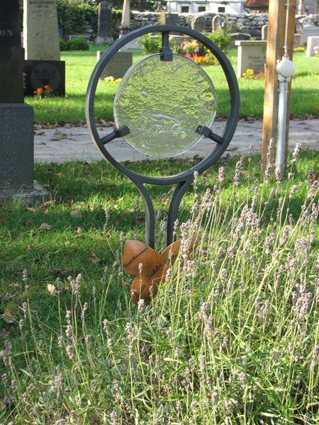 Vård av järn och glas rest över textilkonstnär Anita Dahlin Bergman (KI Gärdslösa kyrkog 066) Smidesvård över smeden Arne Gustavsson rest 1988.