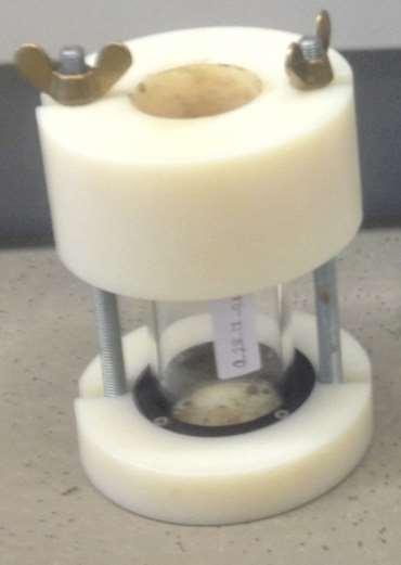 Notera klisterlappen på cylindern på vilken provkroppens namn och tillverkningsdatum står. Då provkroppen är packad avlägsnas det material som sticker upp ovanför glascylinderns ovankant.