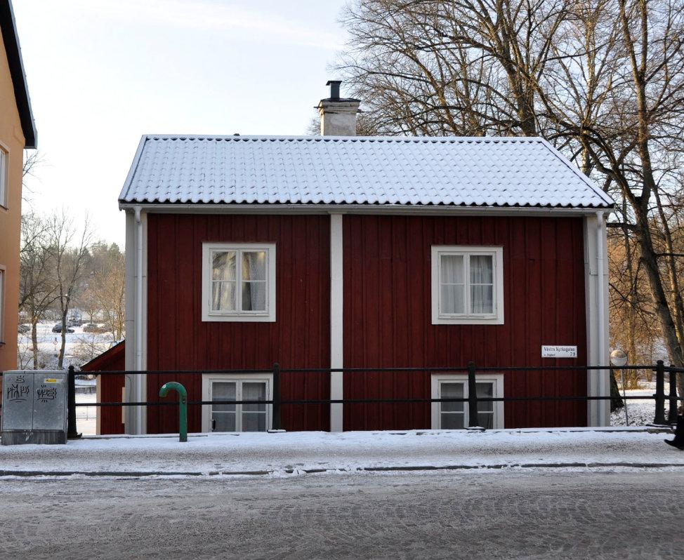 enbart en dörr klädd med locklistpanel. Fönstersnickerier är vitmålade och dörrarna är svarta.