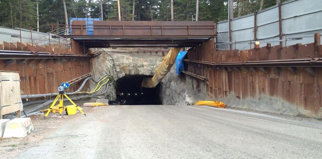 Foto på tunnelmynningen med plank mot St. Botvids väg (Foto: Fennia Carlander) Bild 2. Tunnelns nedfart och mynning sett från arbetsområdet.