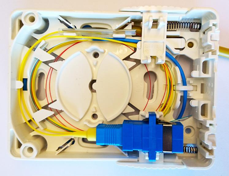 Kabeln placeras under hållarna på uttagets baksida. Bilden visar installation när mellanstycket är placerad på vänster sida (sett framifrån).