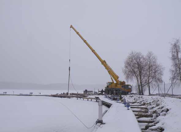 PÅLNING Mobilkran med lufthammare i hamnen Fredagen den 27 februari hade USS tagit ner mobilkran med trycklufthammare till hamnen för att täppa till den sista öppningen mot Ekoln vid vågbrytaren.