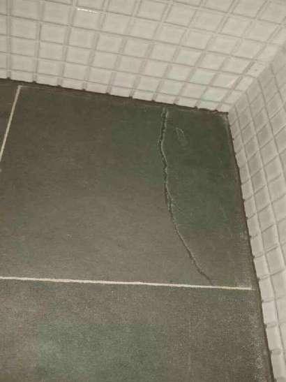 En klinkerplatta brevid toalettstolen i ena hörnet har bomljud. Risk att klinkerplattan kan lossna. Men bedöms ej ha lett till bakomliggande skador.