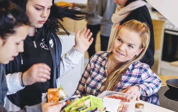 Det är lätt att trivas med barn och unga. Skoleleverna Katja Aalto (t.v.) och Satu Kurkinen tillreder pizzafyllning. Maria Sipari hjälper till.