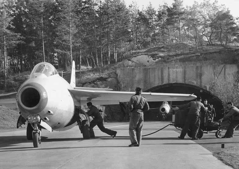 J 29:or på väg ut från en berghangar. På fem av jaktflottiljerna ordnades skydd för en del av flygplansbeståndet i form av hangarer i berg. Foto: SFF.