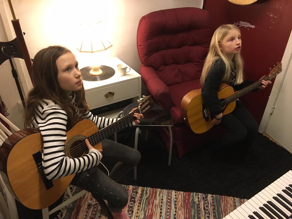 Två glada musiker som lirar gitarr i Musiken J Hej alla 3:or!