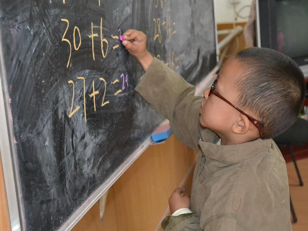 En pojke i barnbyn övar på matematik. Foto: SOS Arkiv Många barn i barnbyn har svåra upplevelser med sig i bagaget när de kommer hit.