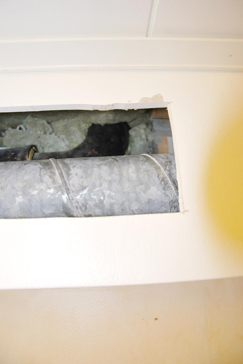 I det fyrkantiga hålet ser man främst ventilationsröret från torkskåpet.