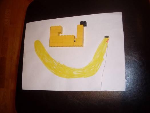 Legobitar på höjden med minst 3 legobitar på höjden och en utbyggnad, en slags dimension på konstruktionen och böjda legobananer.