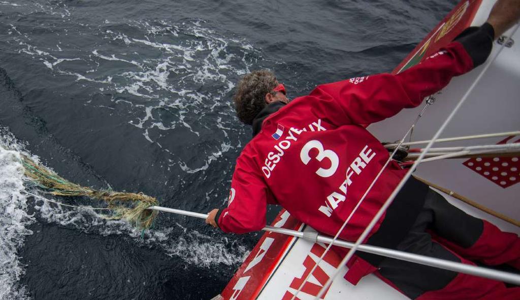 Gammalt fiskenät som flyter i havet kallas för spöknät och utgör 10% av plastföroreningarna i havet. a MAPFREs seglare Desjoyeaux tar bort fiskenät från båtens roder!