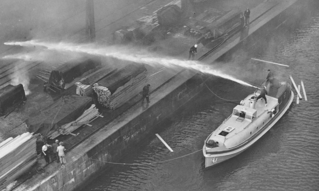 Sjöångsprutan NILS i aktion vid brand i träupplag i hamnen.