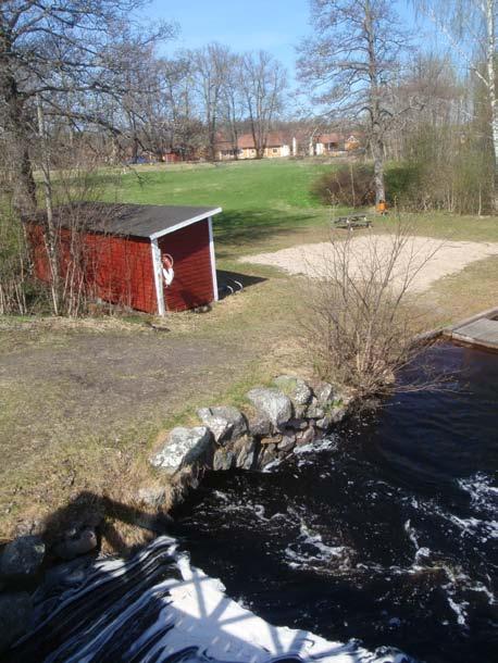 Figur 4. I förgrunden visas stenvalvet vid utloppet av rännan/ diket RAÄ 143:1. I bakgrunden syns befintligt omklädningsrum i anslutning till badstranden. Foto från SÖ.