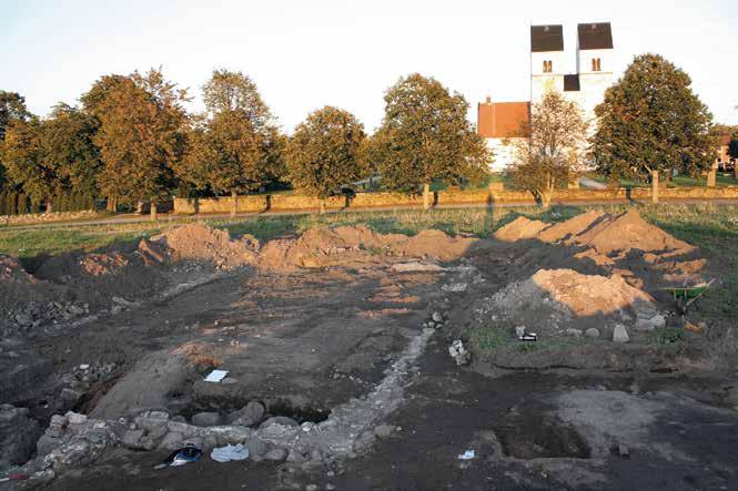 Stenbyggnaden väster om kyrkan.