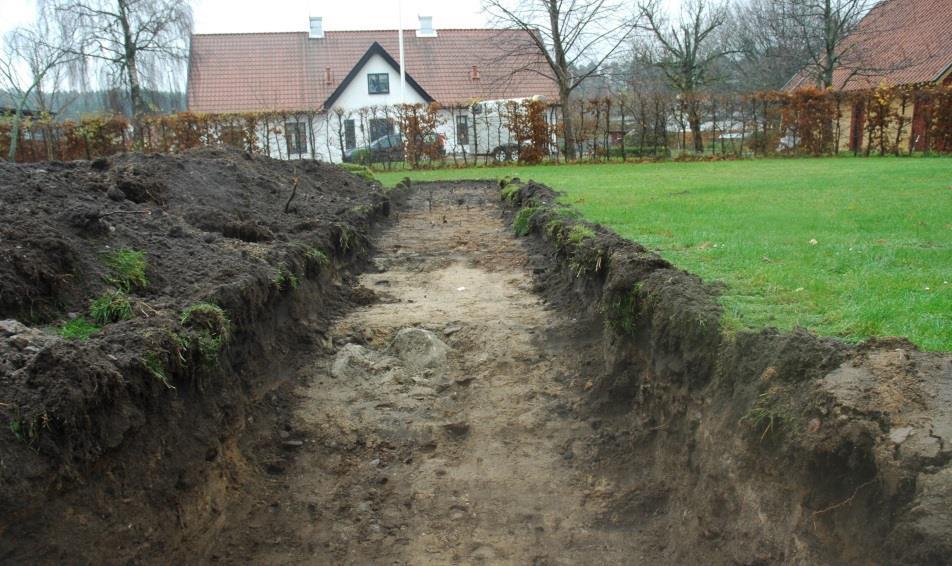 Raseringsmassorna innehöll en stor mängd sten och tegel (gult, maskintillverkat med måtten: 0,24 x 0,11 x 0,06 m). I schaktets mitt och i den västra delen påträffades två större nedgrävningar.